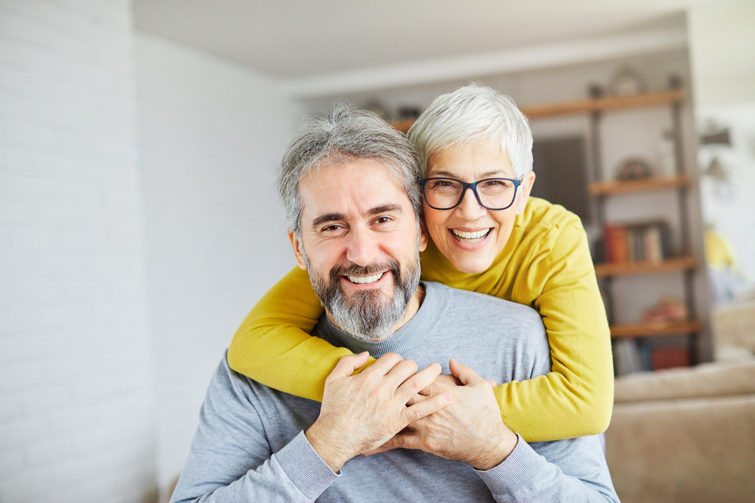 Smiling older couple embracing, the kind of long-time patients who bring their families